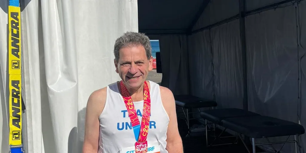 Community fundraiser, Bernie smiles at camera after completing the City to Surf in Sydney.