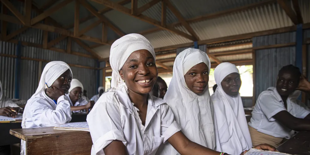 Refugee students smile at camera. In Kakuma Refugee Camp, UNHCR is advocating for technical support and financing for the inclusion of refugees and camp-based schools in the national education system.