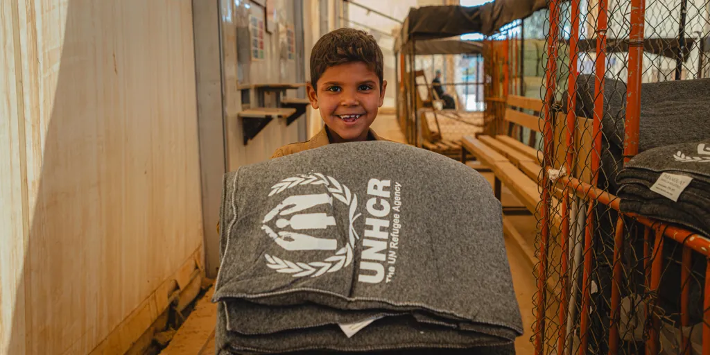 Jordan_Refugee boy collects winter blankets in Za'atari camp
