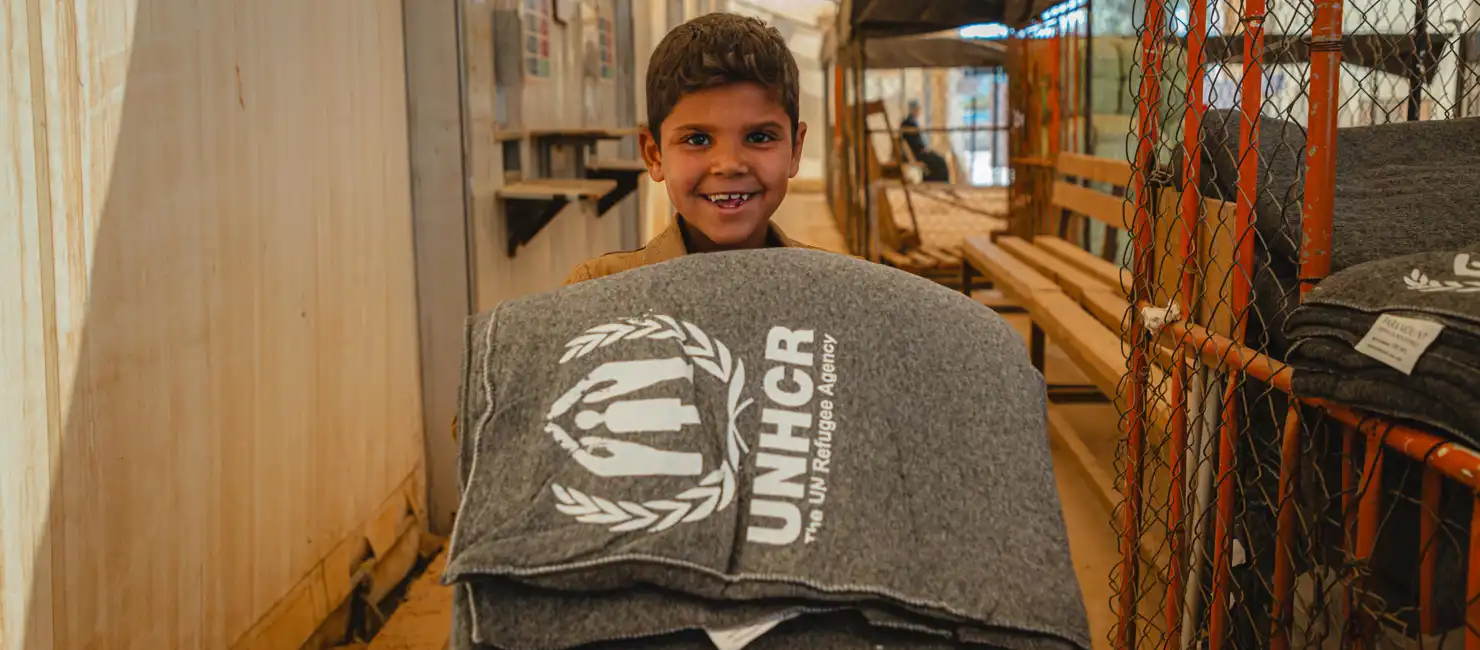 Jordan_Refugee boy collects winter blankets in Za'atari camp
