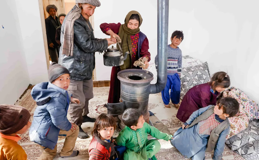 Afghanistan. Alijuma Nikbakht and his family enjoy the warmth of their new house