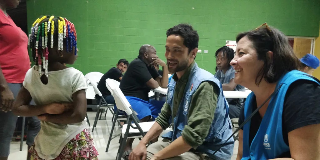A young child speaks to UNHCR worker and Trudi Mitchell at Guatemala migrant shelter