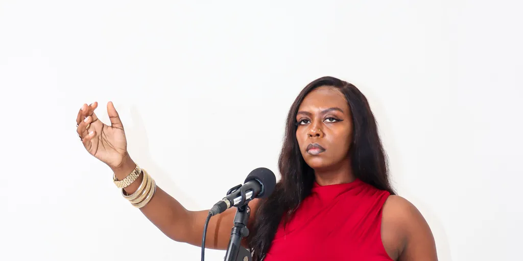 Slam poet Huda the Goddess performs at a microphone. She is the winner of the 2025 Australia for UNHCR - SBS Les Murray Award for Refugee Recognition.