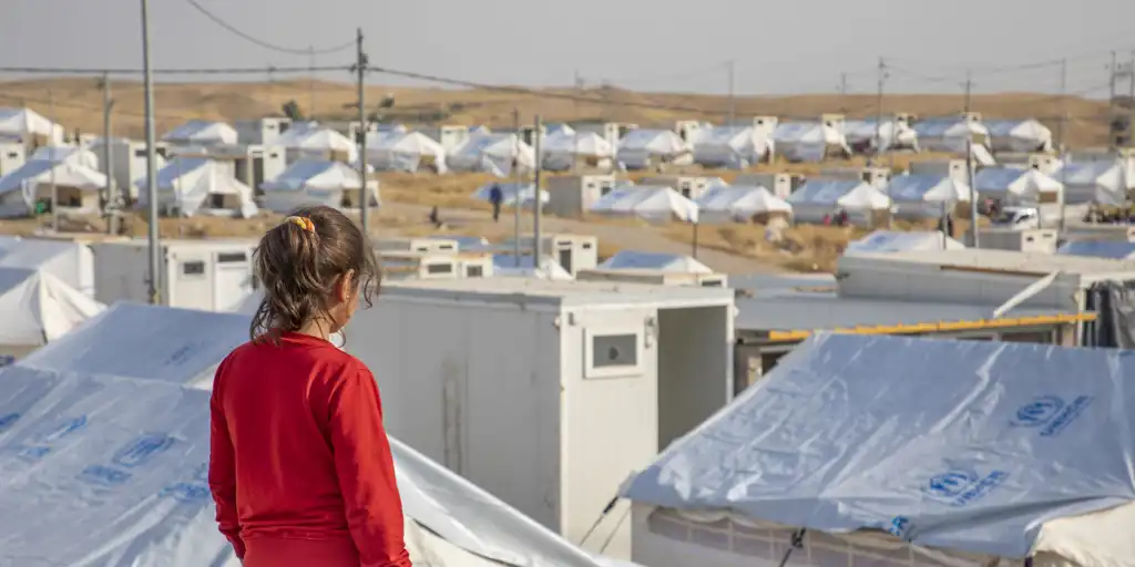 tile_iraq_refugee-child-looking-at-unhcr-camp