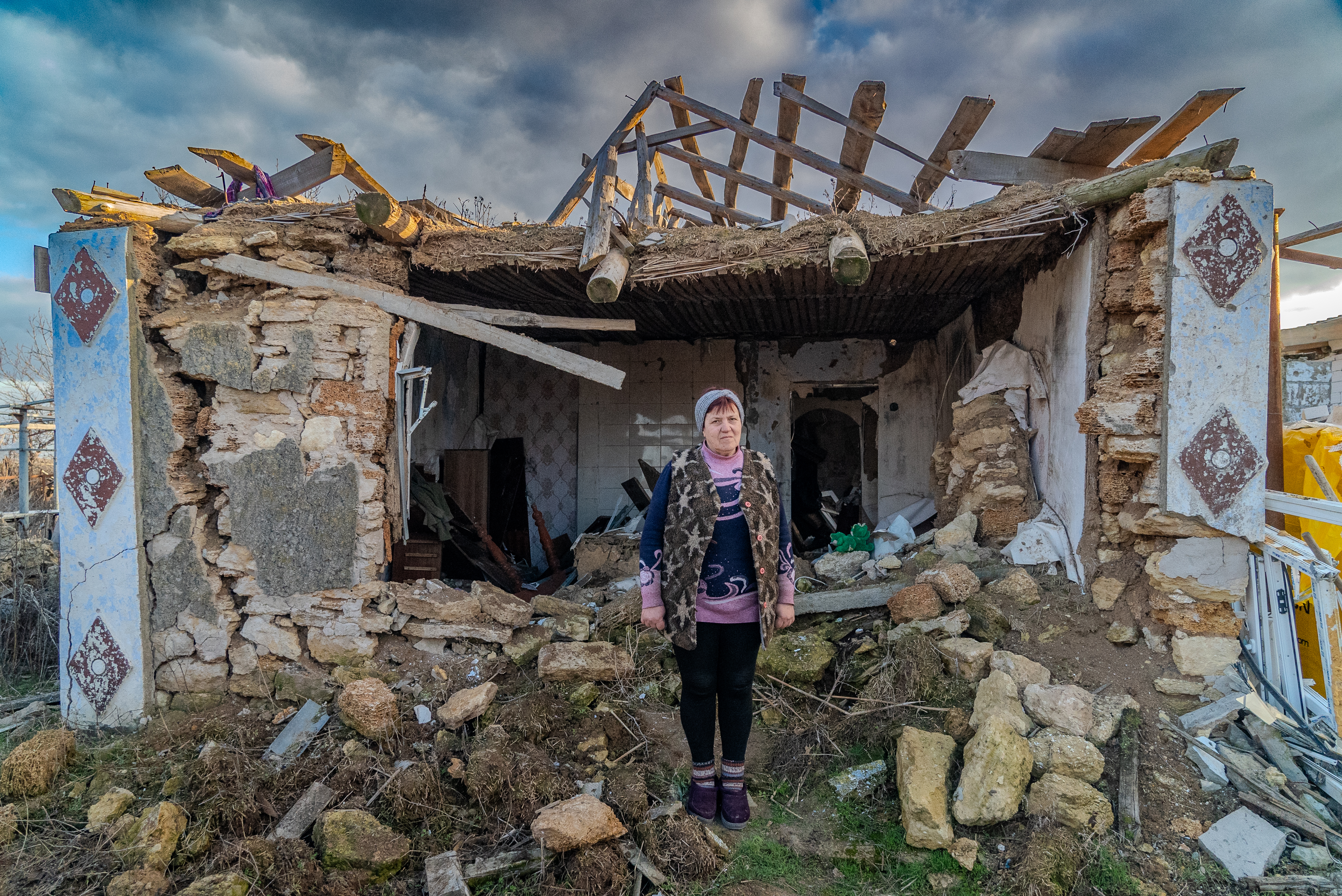 Ukraine_Valentyna stands outside her destroyed home in Mykolaiv, Ukraine