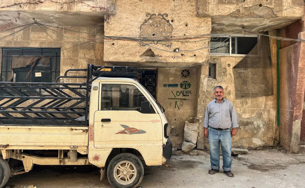 syria_khaled-stands-outside-his-repaired-home