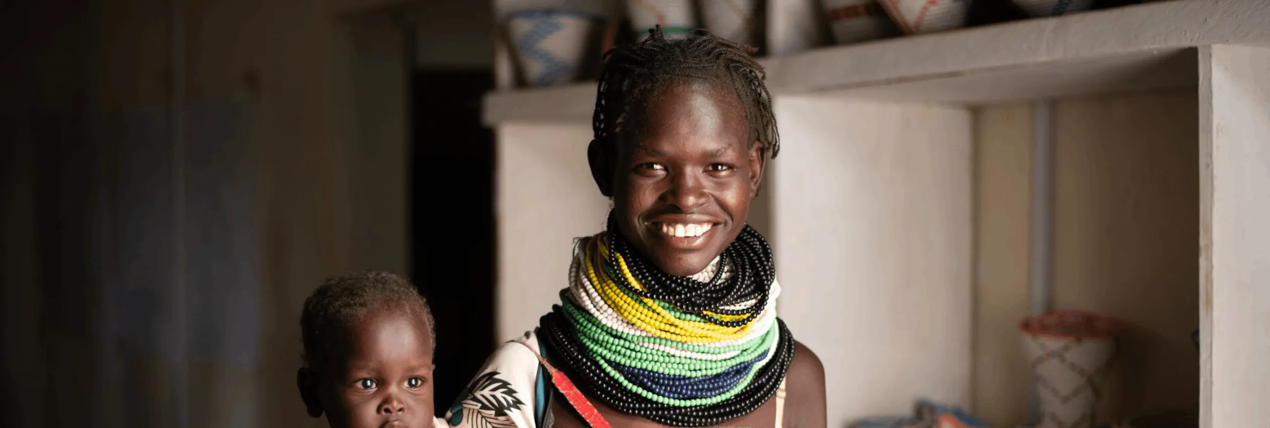 banner_kenya_kenyan-woman-wearing-beaded-jewelery-holding-her-baby