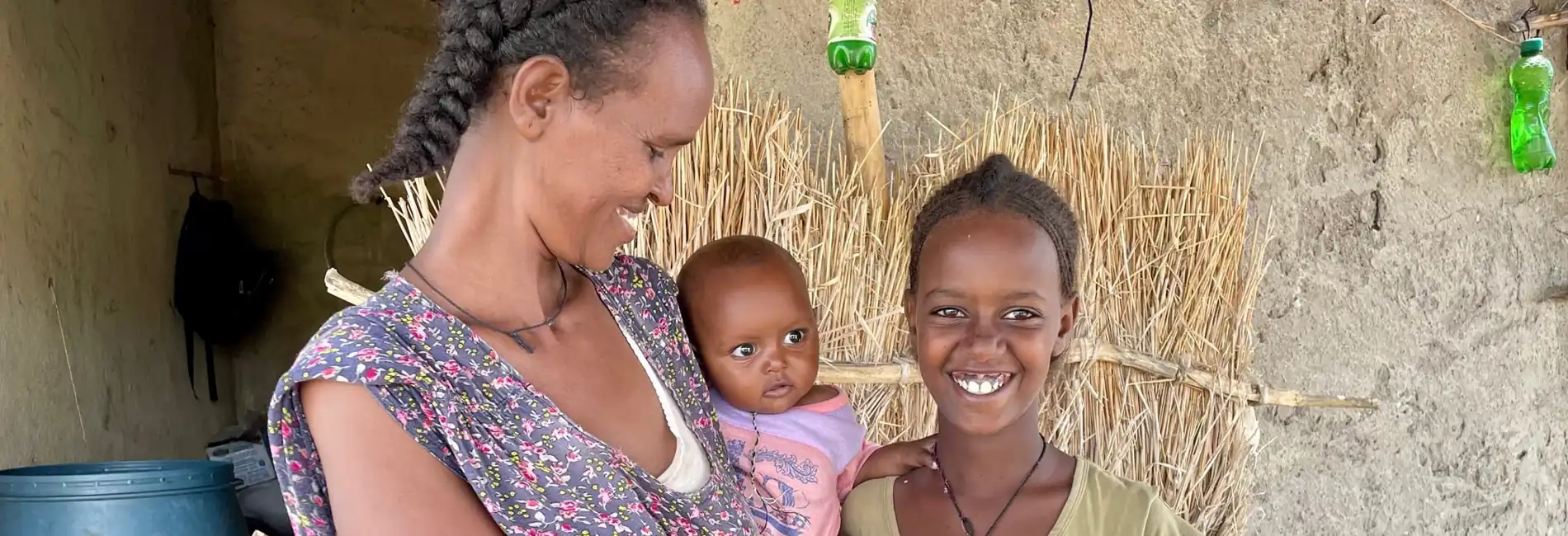 Sudan_Letha-Eymaret-and-baby-Madher-stand-outside-their-home