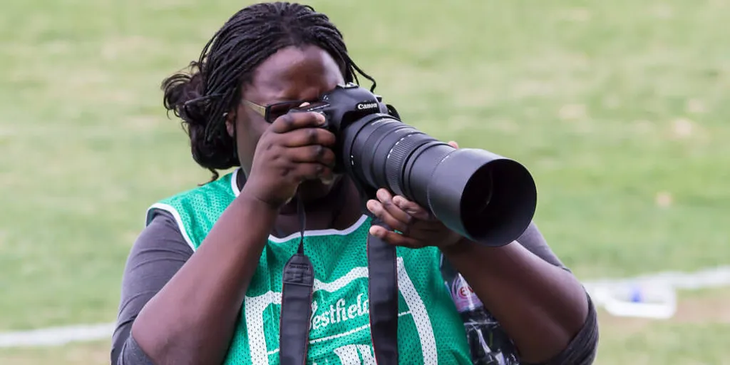 Australian sports journalist Ann Odong takes photos at a sports field